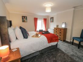 A bedroom with a bed and chest of drawers at Daisy Cottage in Wigton