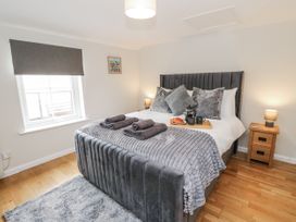 A bedroom with a bed and bedside table at Daisy Cottage in Wigton