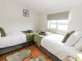 A bedroom with twin beds and a window at Daisy Cottage in Wigton