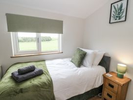 A bedroom with a single bed and window at Daisy Cottage in Wigton