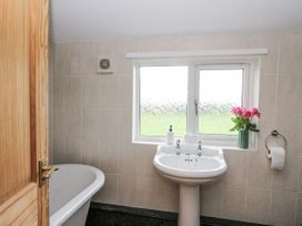 A bathroom with a wash basin and bath tub at Daisy Cottage Wigton