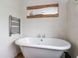 A bathroom with a bathtub and a towel radiator at Daisy Cottage in Wigton