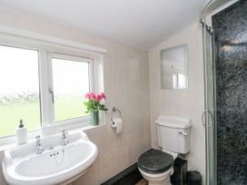 A bathroom with a sink, toilet and shower at Daisy Cottage in Wigton
