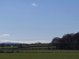 A view of fields and trees under a blue sky at Daisy Cottage Near Wigton