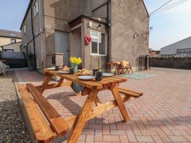 An outdoor area with a picnic table and chairs at Daisy Cottage near Wigton