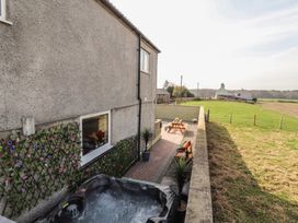 An outdoor area with a hot tub and seating at Daisy Cottage near Wigton