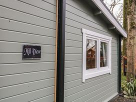 The exterior side wall of a building with a white-framed window and a sign that reads Mill View near two trees at Mill View in Dungiven Londonderry