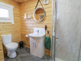 A bathroom with a toilet sink shower and round mirror at Owenbeg in Dungiven Londonderry