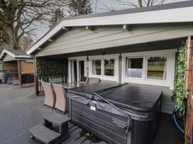 An outdoor patio with a hot tub table and chairs on a deck at The Roe in Dungiven Londonderry