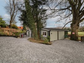 A gravel driveway with trees and a small building at The Roe in Dungiven Londonderry