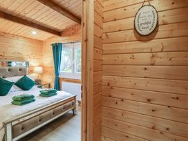 A bedroom with a bed towels and pillows next to a window with blue curtains at The Roe in Dungiven Londonderry