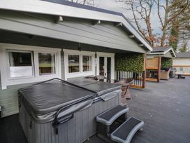 An outdoor deck with a hot tub and steps a round table with chairs and a covered seating area at The Castle in Dungiven Londonderry