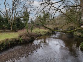 A river with bare trees and a stone bridge in the background at Hazel in Dungiven Londonderry