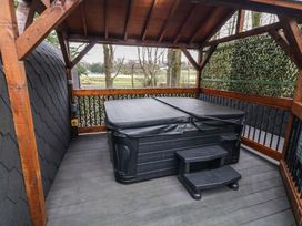A covered outdoor area with a hot tub and steps surrounded by wooden beams at Birch in Dungiven Londonderry