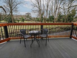 A patio with two chairs and a small round table overlooking trees at Birch in Dungiven Londonderry