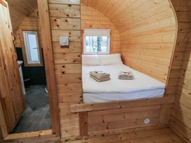 A bedroom with a bed and folded towels next to a small bathroom with a window at Elm in Dungiven Londonderry