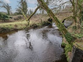 A river with trees on its banks and a stone bridge in the background at Hawthorn in Dungiven Londonderry