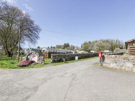 A road entrance with a stone wall and a red postbox near Three Lochs Holiday Park near Glenluce