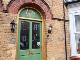 A green door with a wall and light fixtures at Rutland Grange in Filey