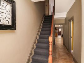 A staircase and clock in a hallway at Rutland Grange in Filey