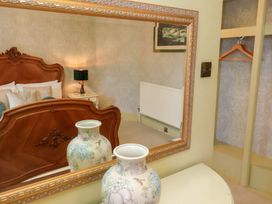 A bedroom with a bed and vase at Rutland Grange, Filey