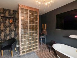 A bathroom featuring a bathtub, shower, and wall-mounted TV at Rutland Grange in Filey