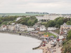 A beach with people and buildings along the shore at Rutland Grange in Filey