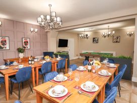 A dining room with a large table set for a meal at Rutland Grange in Filey