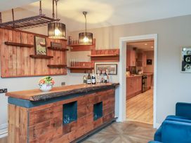 A dining room with a bar and kitchen area at Rutland Grange in Filey