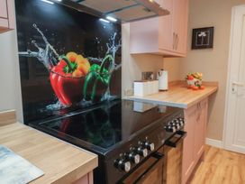A kitchen with a stove, kettle, and fruit on the countertop at Rutland Grange in Filey