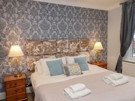 A bedroom with a bed and lamps at Rutland Grange in Filey