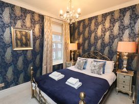 A bedroom with a bed and nightstands at Rutland Grange in Filey