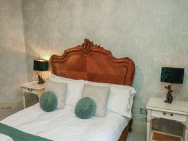 A bedroom with a wooden bed and lamps at Rutland Grange in Filey