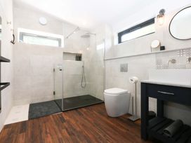 A bathroom with shower, toilet, and sink at Y Cwt in Moelfre