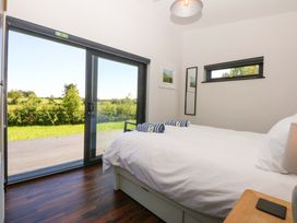 A bedroom with a bed and sliding door at Y Cwt in Moelfre