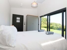A bedroom with a bed and wardrobe at Y Cwt in Moelfre