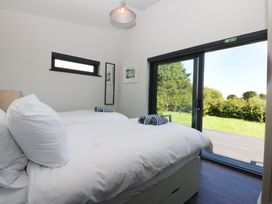 A bedroom with two beds and a view of the outside at Y Cwt in Moelfre