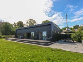 An outdoor view of a house with a patio and seating area at Y Cwt in Moelfre
