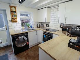 A kitchen with a washing machine sink stove oven microwave and coffee machine at 3 Victoria Cottages Heacham