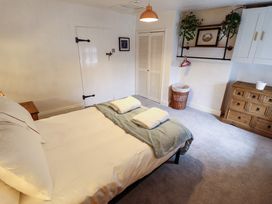 A bedroom with a bed towel on a throw a wooden chest of drawers and a linen basket at 3 Victoria Cottages in Heacham