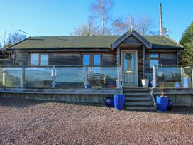 A wooden cabin with a glass railing and blue plant pots at Hillview in Stottesdon near Cleobury Mortimer