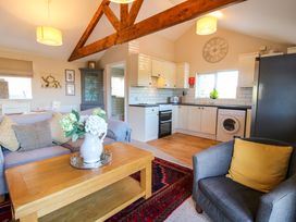 An open plan living room and kitchen with a wooden coffee table and sofa at Hillview in Stottesdon near Cleobury Mortimer