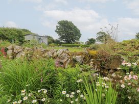 A garden with flowers and a stone wall at Teg in Prospidnick near Porthleven