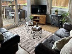 A living room with a sofa, coffee table, and television at Number 39 Bodmin