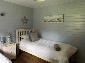 A bedroom with two beds and a side table at Number 39 in Bodmin