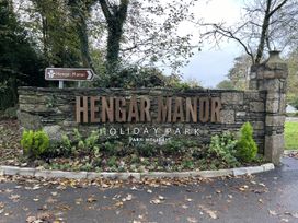 A sign for Hengar Manor Holiday Park with surrounding greenery at Hengar Manor in Bodmin