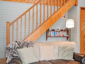 A living room with a staircase and sofa at Cornish Woodland Retreat Near St Tudy