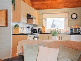 A kitchen with cabinets and appliances at Cornish Woodland Retreat Near St Tudy