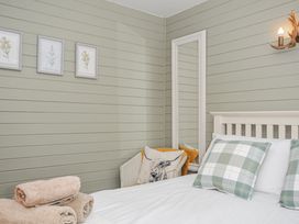 A bedroom with a bed and towels at Cornish Woodland Retreat near St Tudy