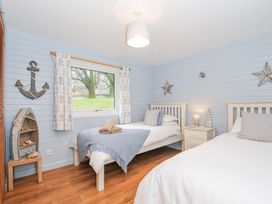 A bedroom with two beds and a window at Cornish Woodland Retreat Near St Tudy